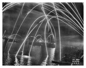 HMS EMPRESS and other ships of the East Indies Fleet in Trincomalee harbour alight with fireworks to celebrate Victory over Japan, V-J night. August 15th 1945.  Photo:  Courtesy John Browne.